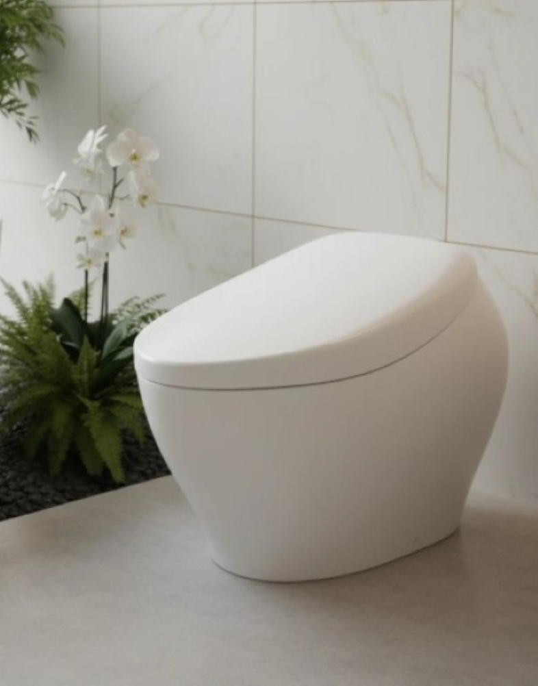 A sleek white modern toilet in a bright tiled bathroom with marble walls and nearby greenery.