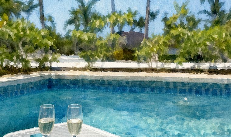 A sunny poolside scene with palm trees, two champagne flutes, and a fruit plate resting on a wicker table.